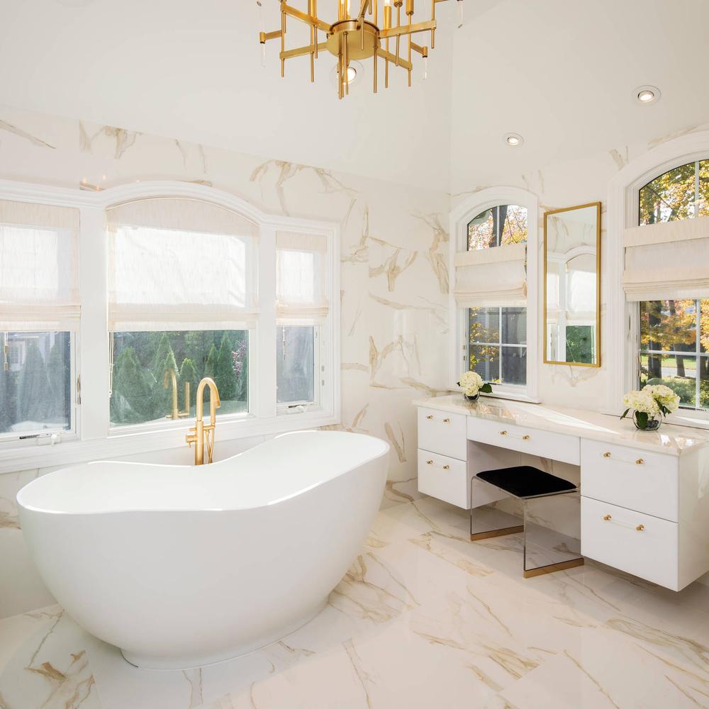 Contemporary bathroom showcasing a freestanding bathtub with gold fixtures.