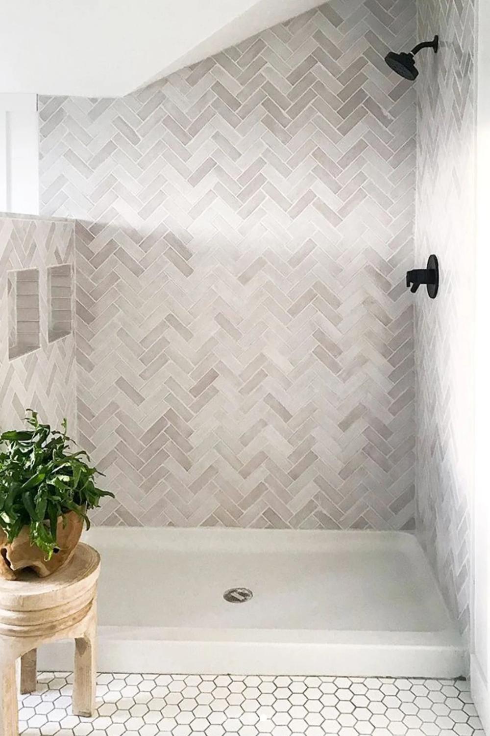 Inviting shower area upholstered in herringbone-patterned tiles