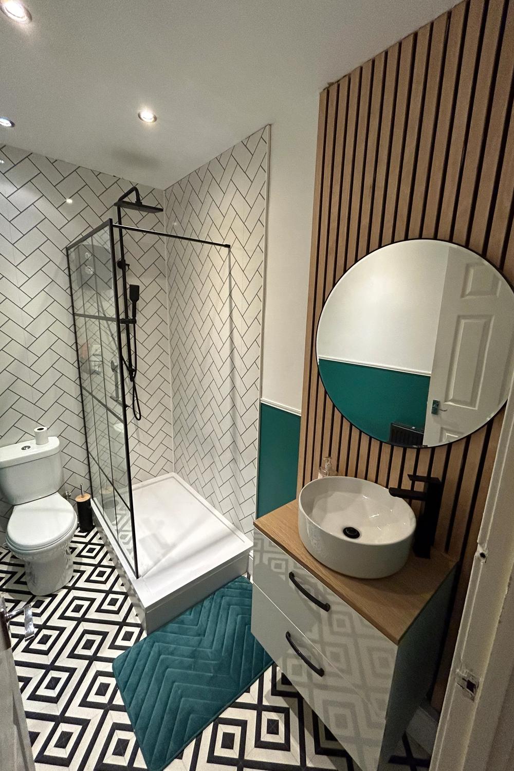 Stylish bathroom showcasing a teal accent wall and herringbone tiles