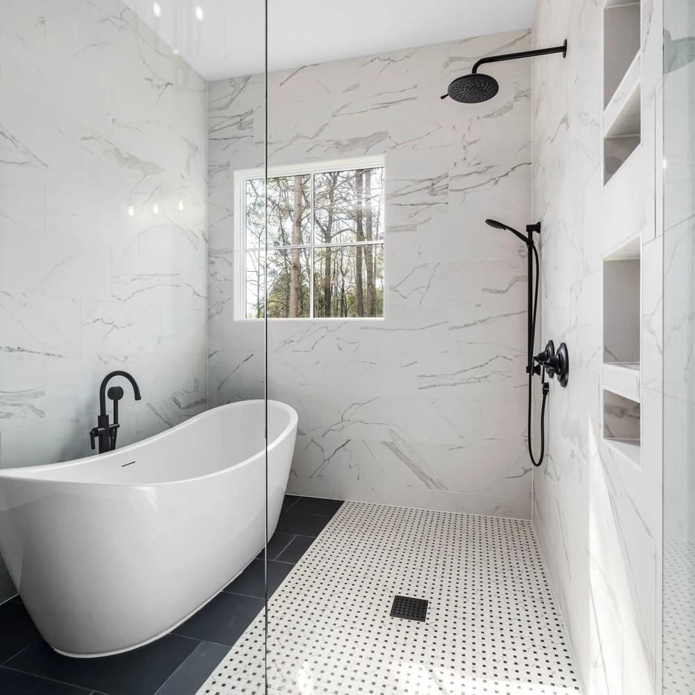 A luxurious bathroom showcasing a serene color palette with white marble surfaces and black accents.