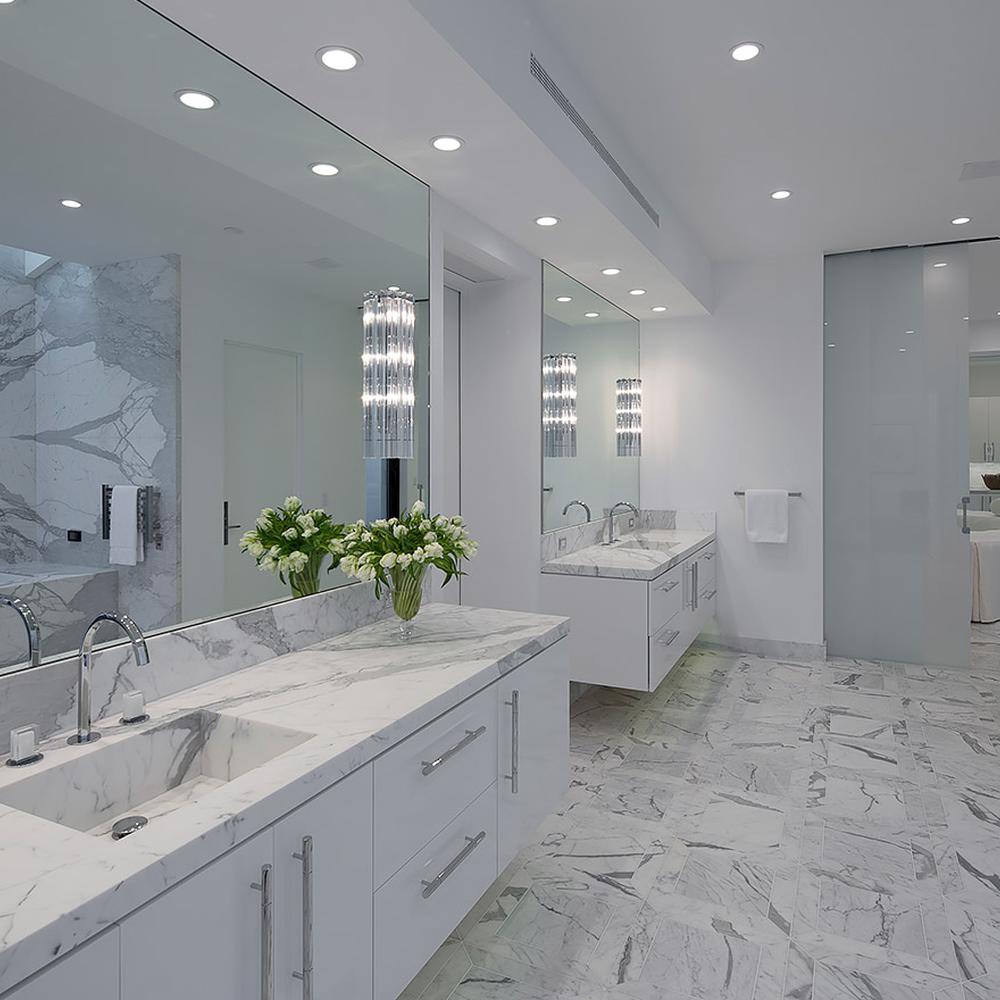 A chic bathroom showcasing a dual vanity with marble accents and elegant lighting fixtures.