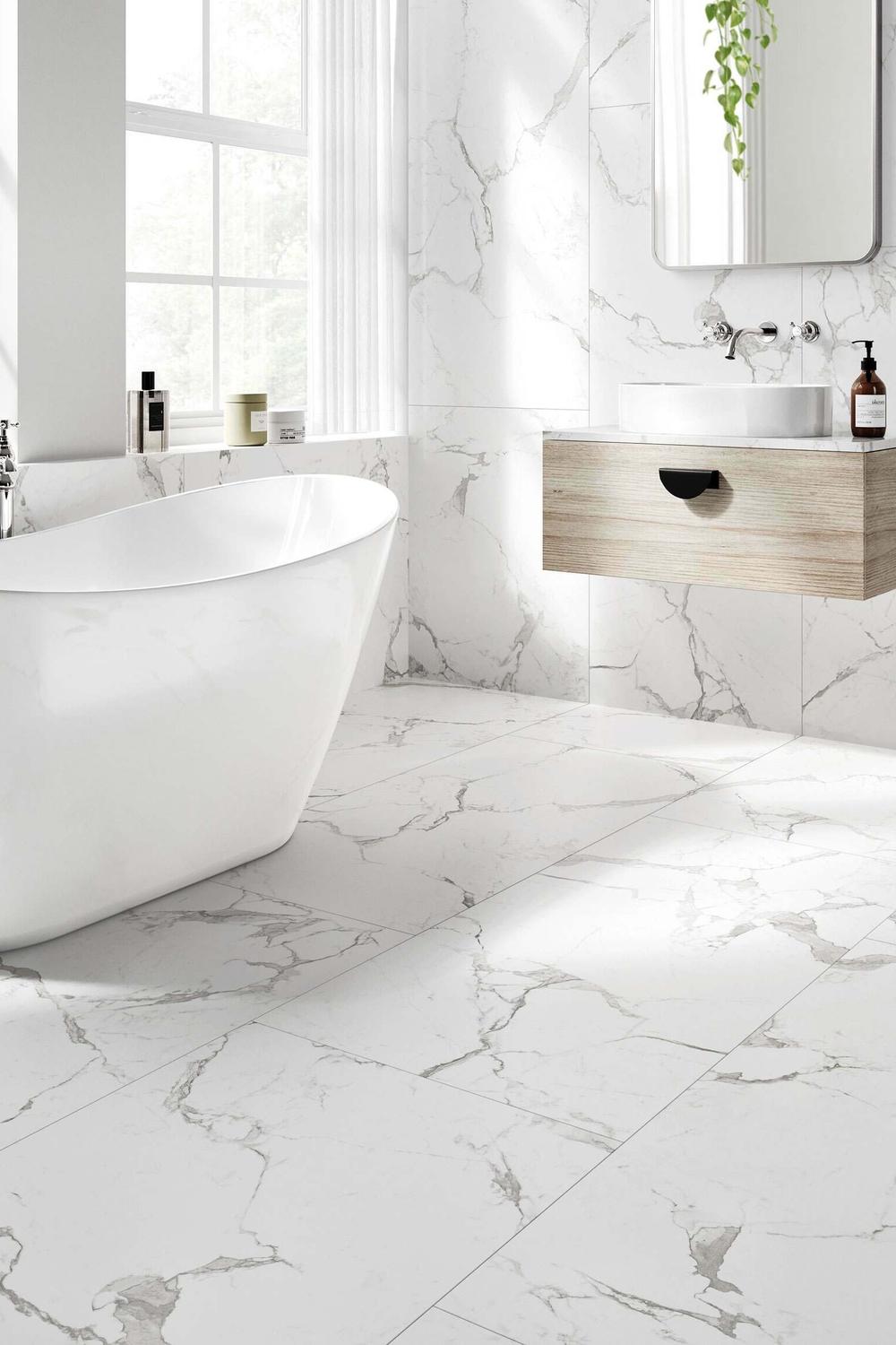 Modern bathroom with proper lighting, white marble tiles, and minimalist fixtures.