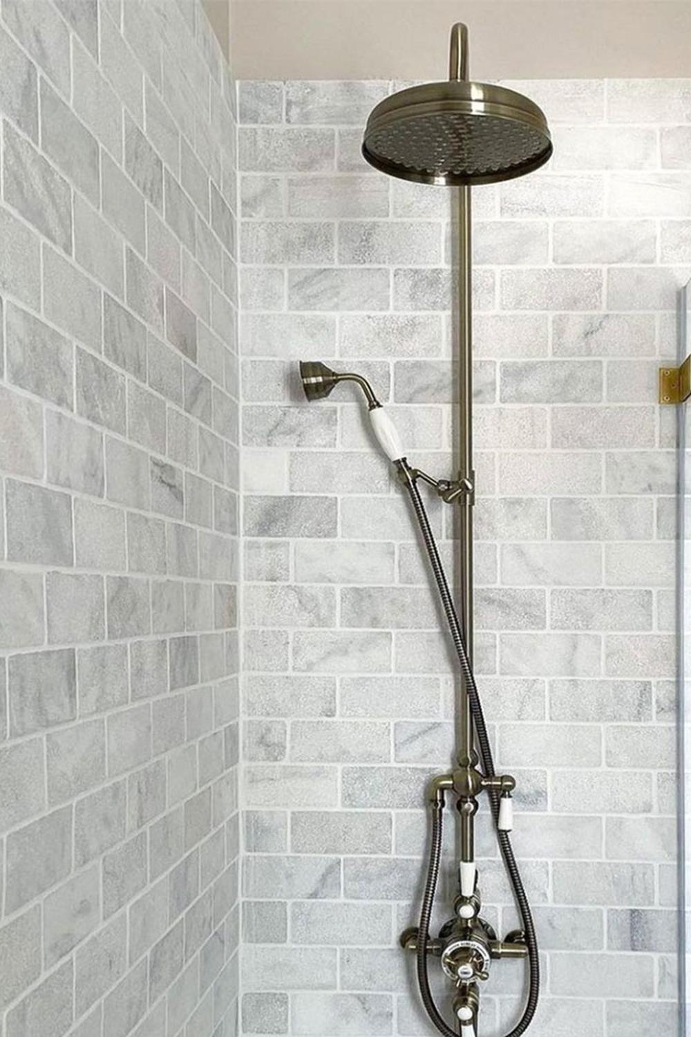 Contemporary bathroom featuring white marble tiles and minimalist shower architecture for a clean aesthetic.