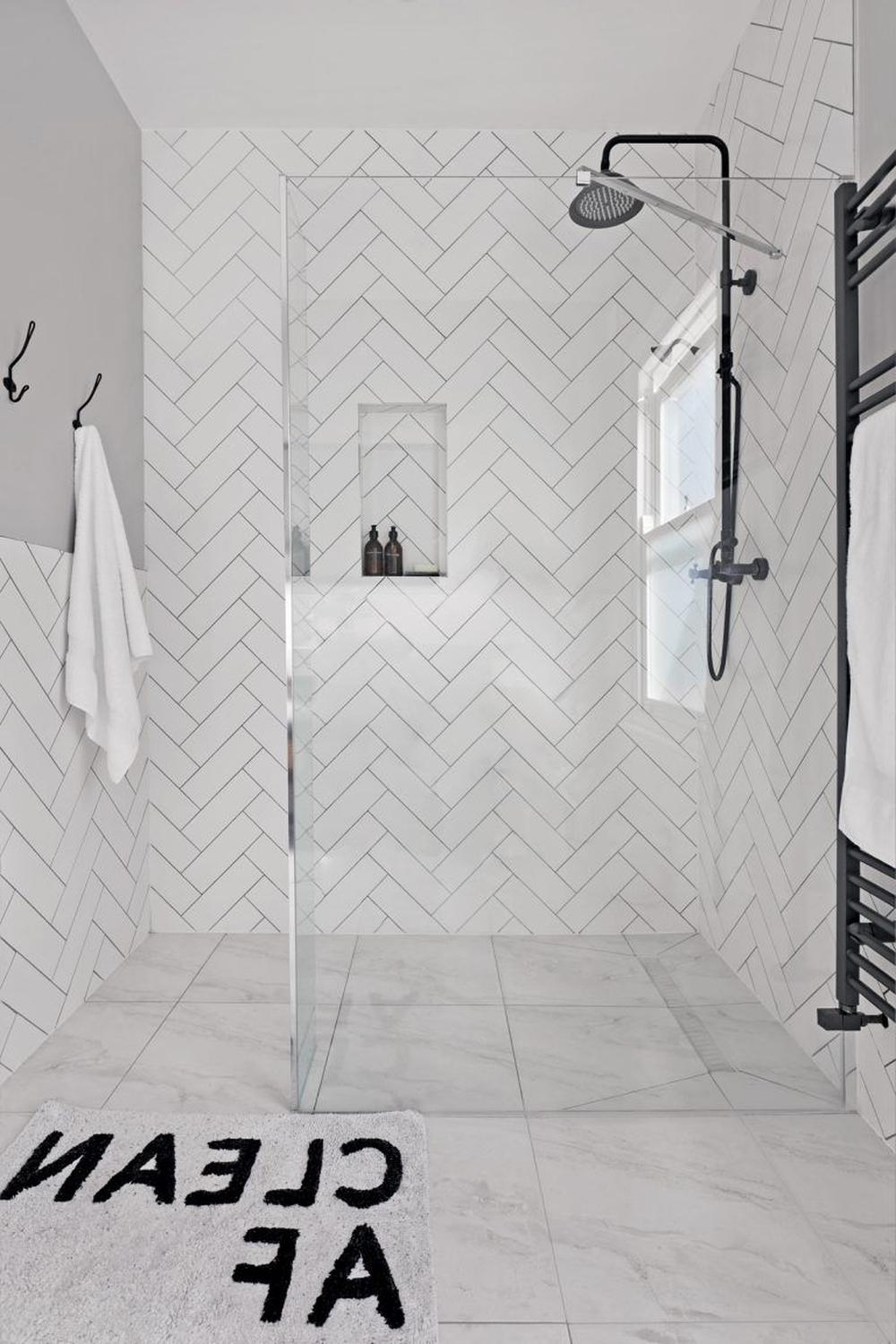 Stylish bathroom showcasing herringbone tiles and sleek storage