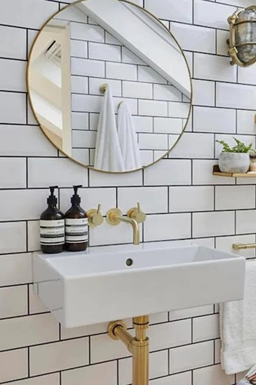 Modern bathroom design showcasing round mirror and chic white metro tiles