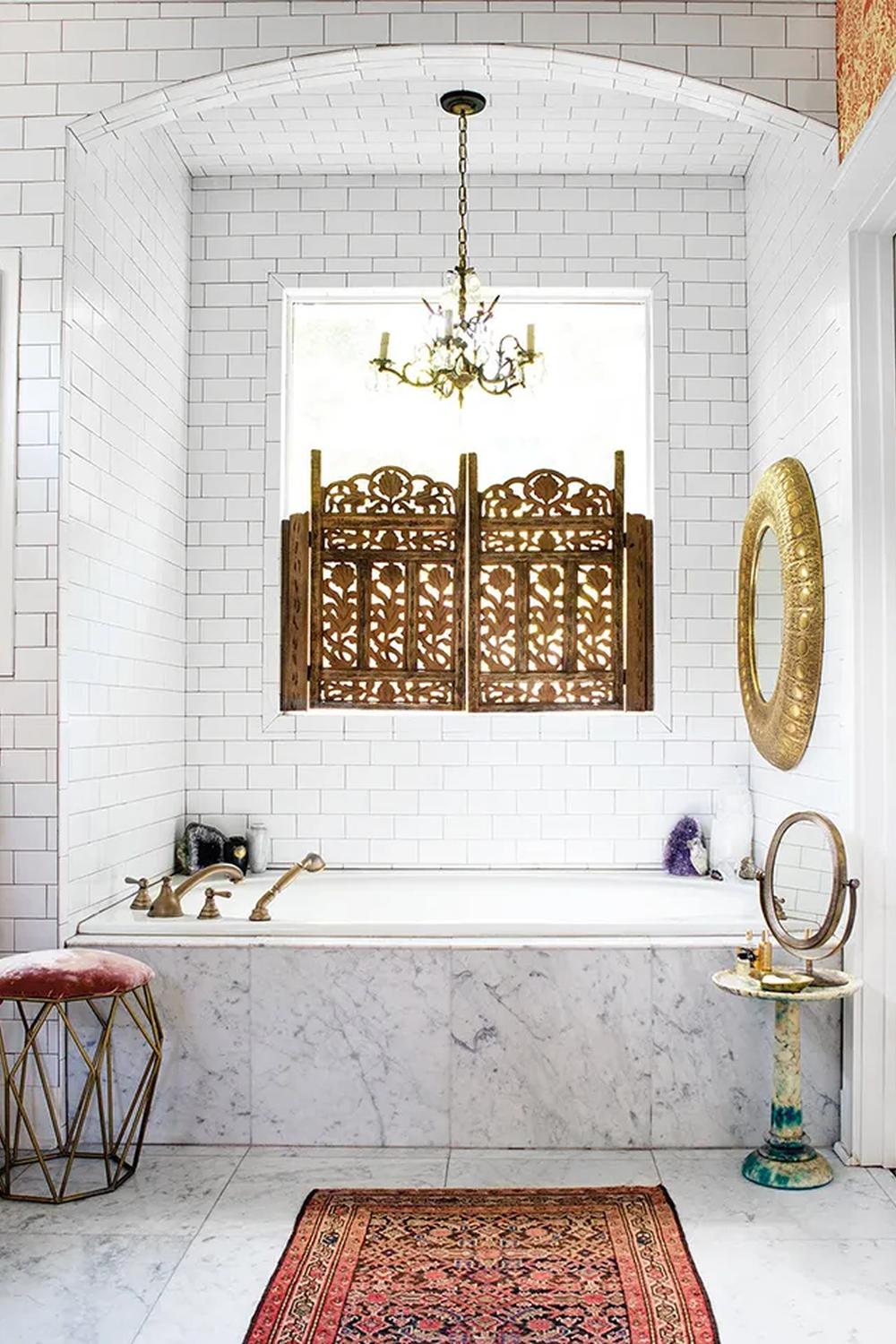 Charming bathroom design featuring white subway tiles, elegant archway, and luxurious freestanding bathtub.