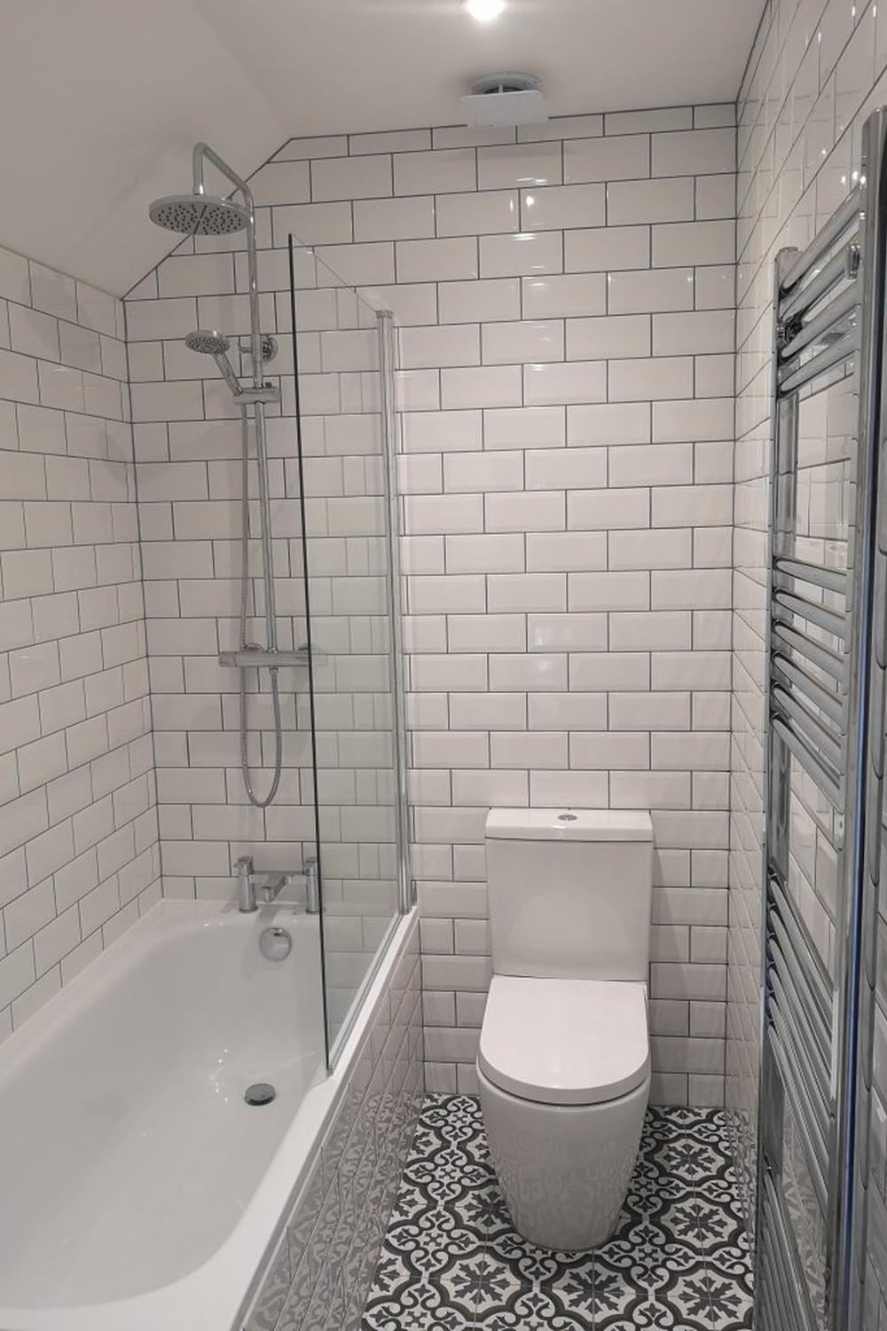 Baño moderno con ducha separada y azulejos blancos