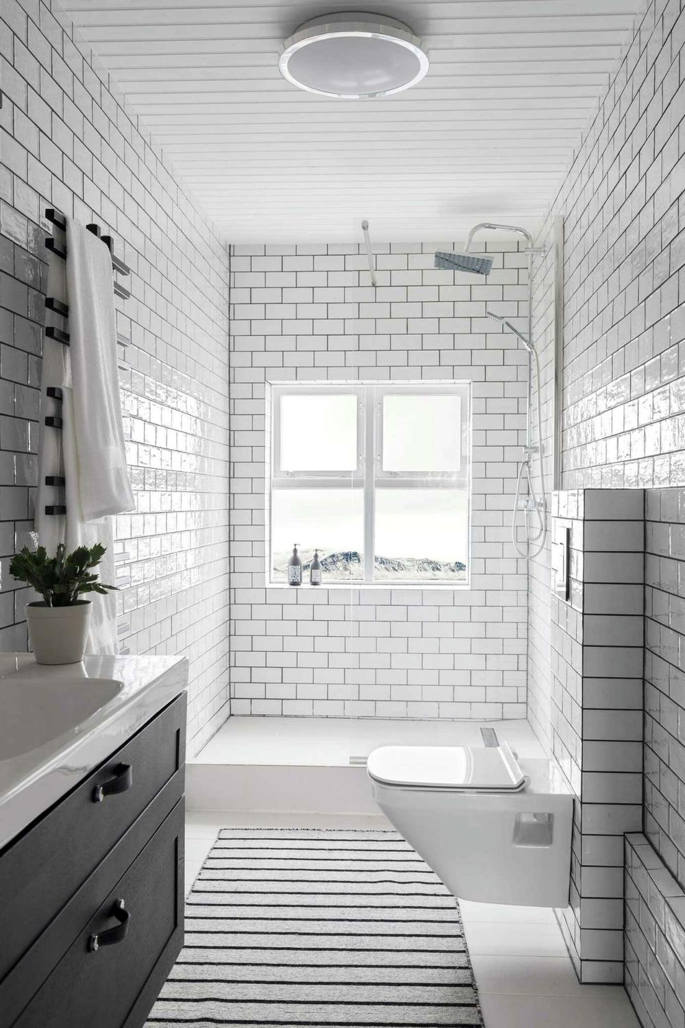 Baño con azulejos rectangulares y luz natural