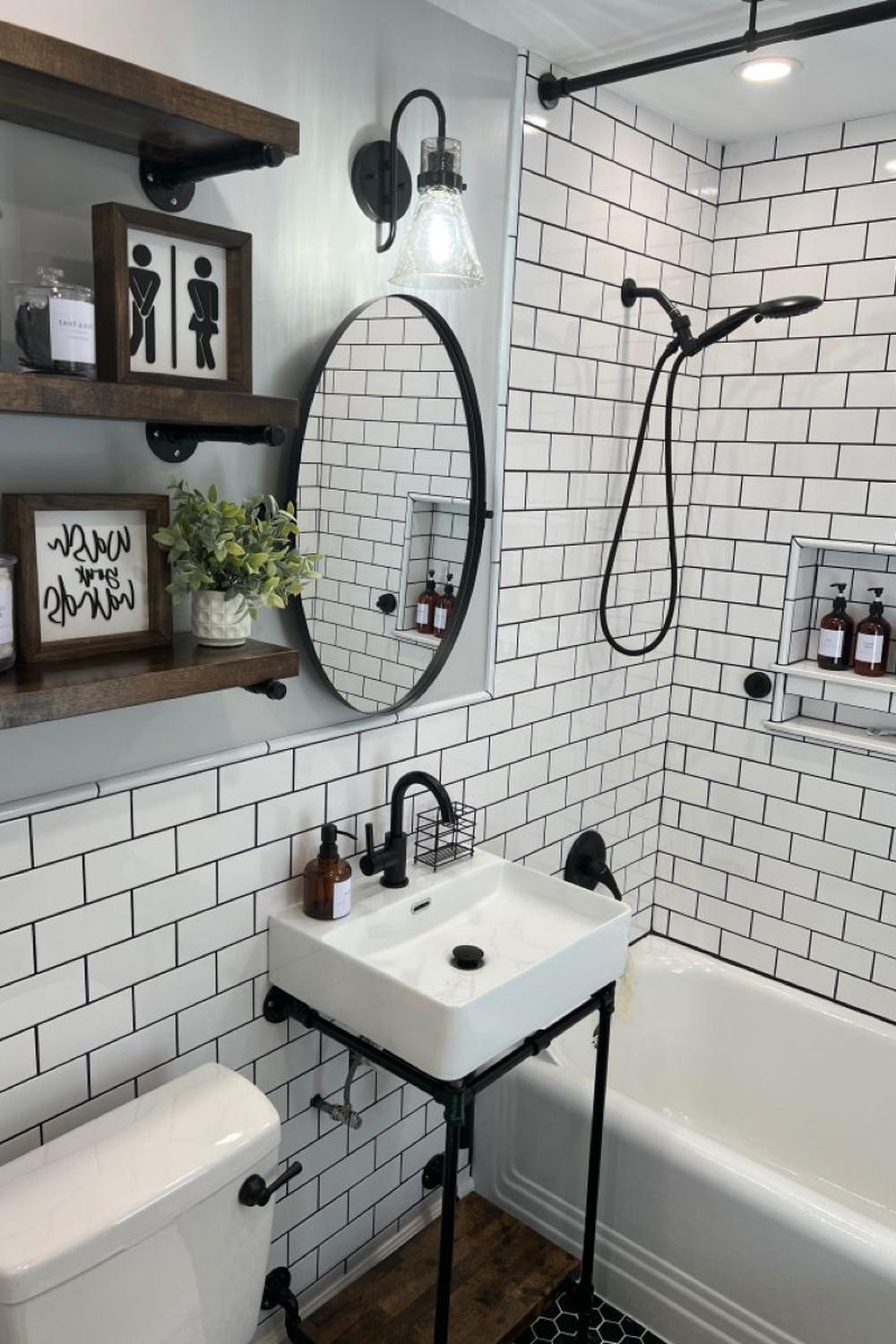 Bathroom showcasing white subway tiles with black grout and a square sink on a black metal frame