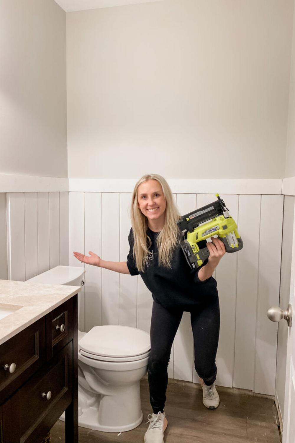 Stylish bathroom with modern fixtures set against white vertical shiplap walls.