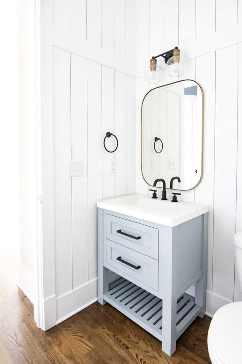 Chic bathroom capturing inviting design elements like vertical shiplap and modern vanity.