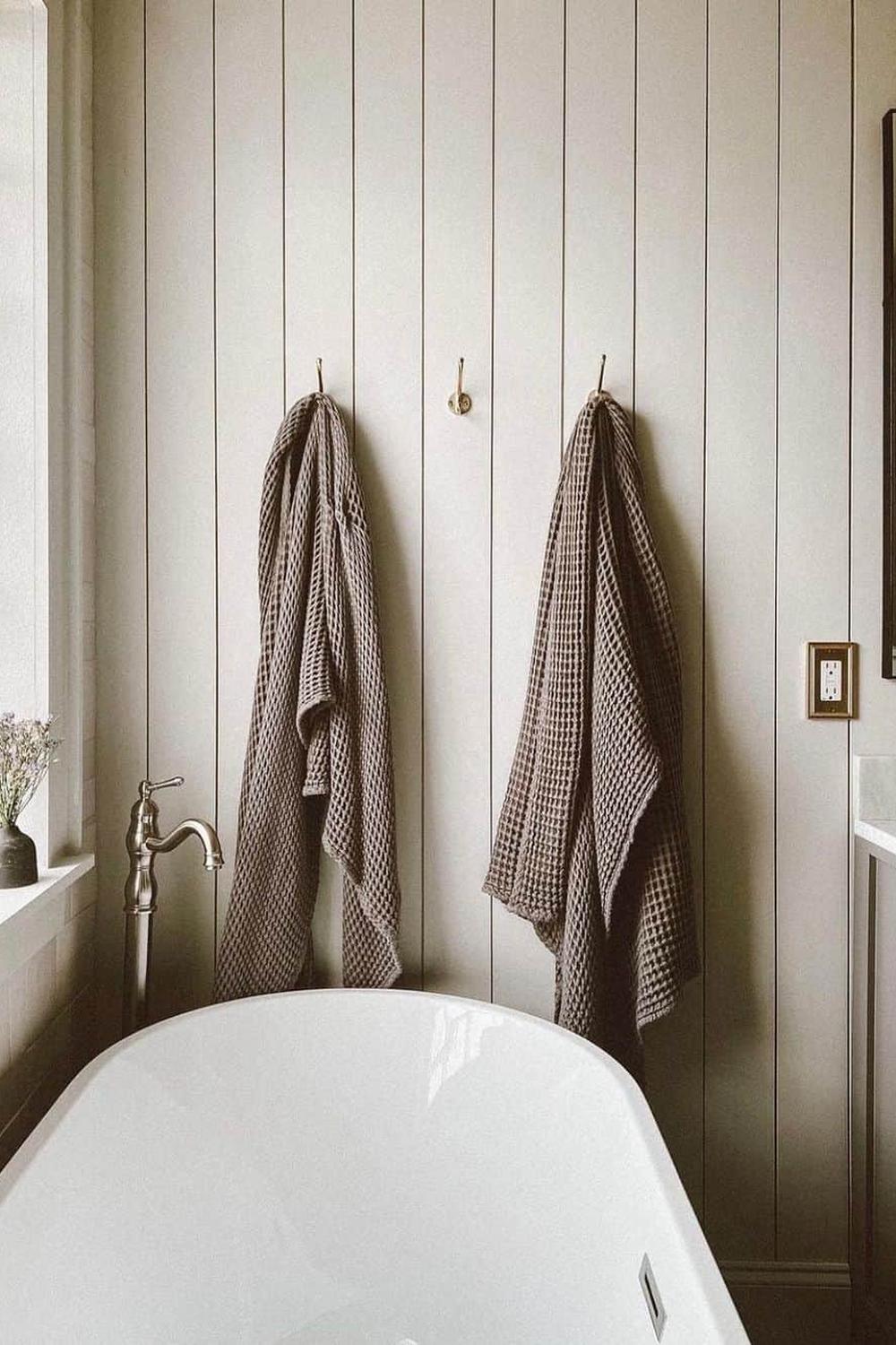 Warm and inviting bathroom with shiplap design, emphasized by natural light and decor accents.