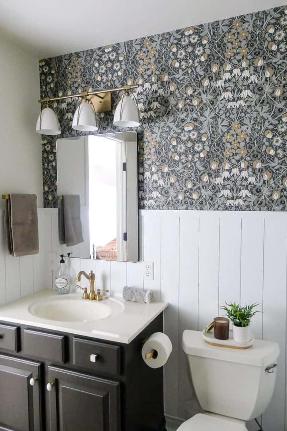 Elegant windowless bathroom designed with floral wallpaper and soft lighting