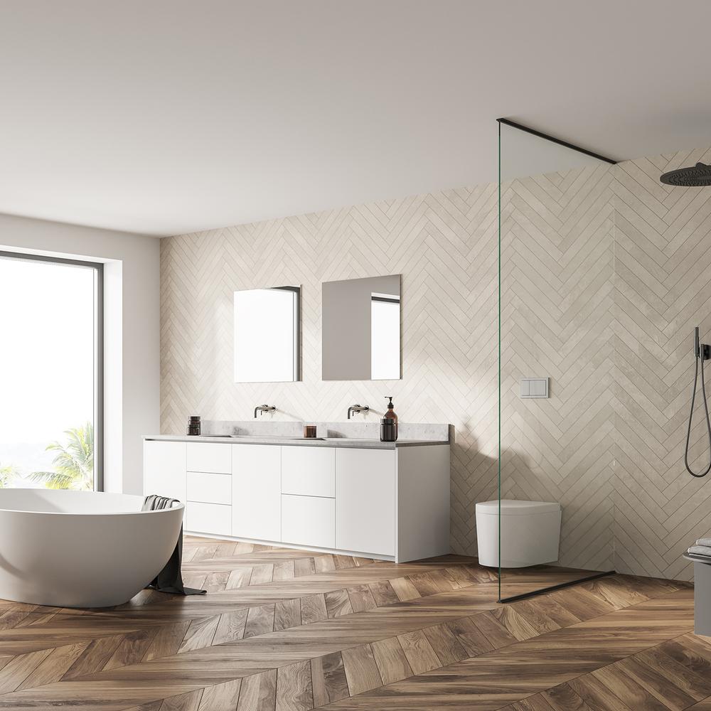 Stylish bathroom showcasing herringbone wood flooring, a white double vanity, and modern mirrors.