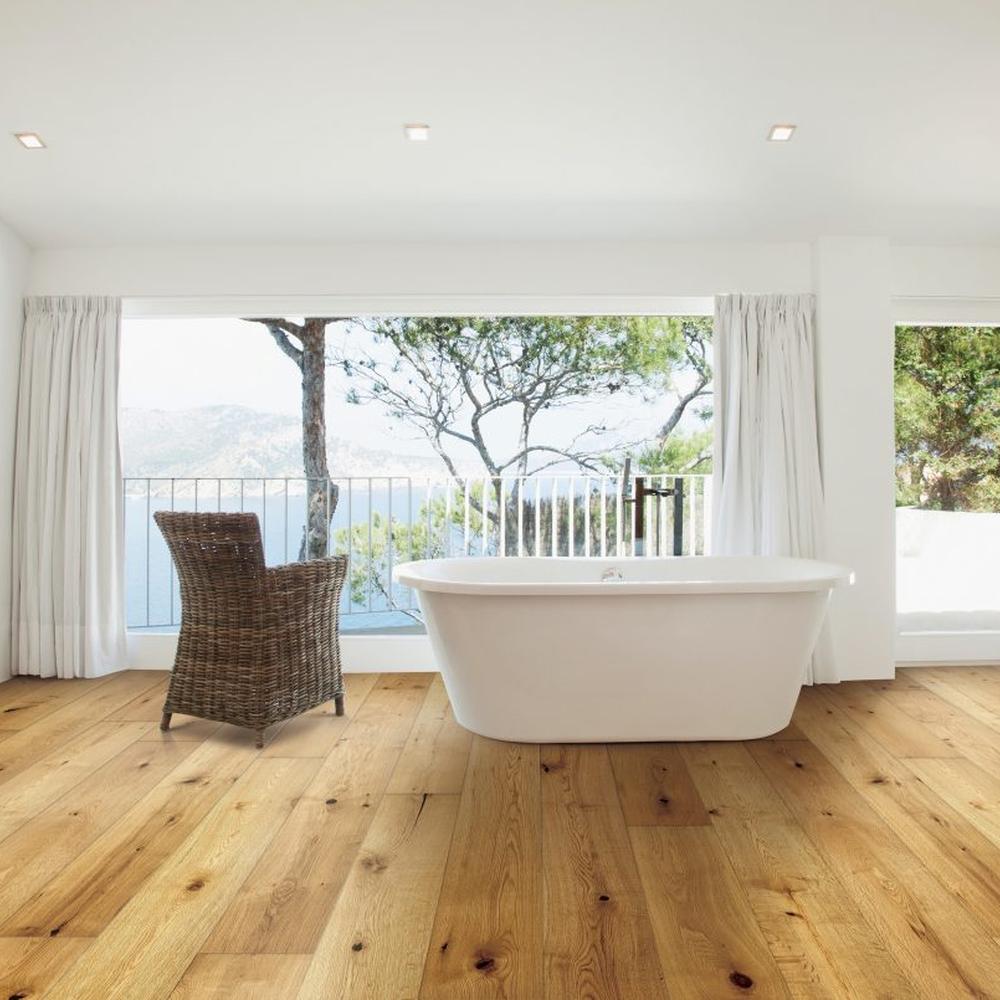 Modern serene bathroom with wooden flooring, freestanding tub, and large windows.