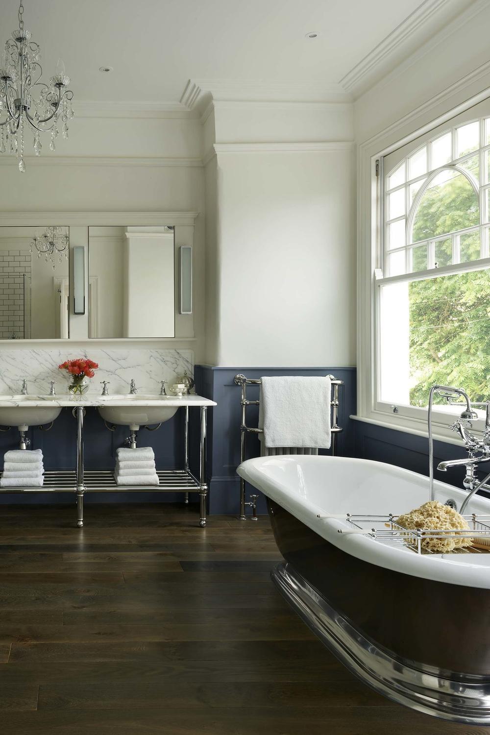 Beautifully designed bathroom with dark wood flooring, double vanity, and elegant accessories.