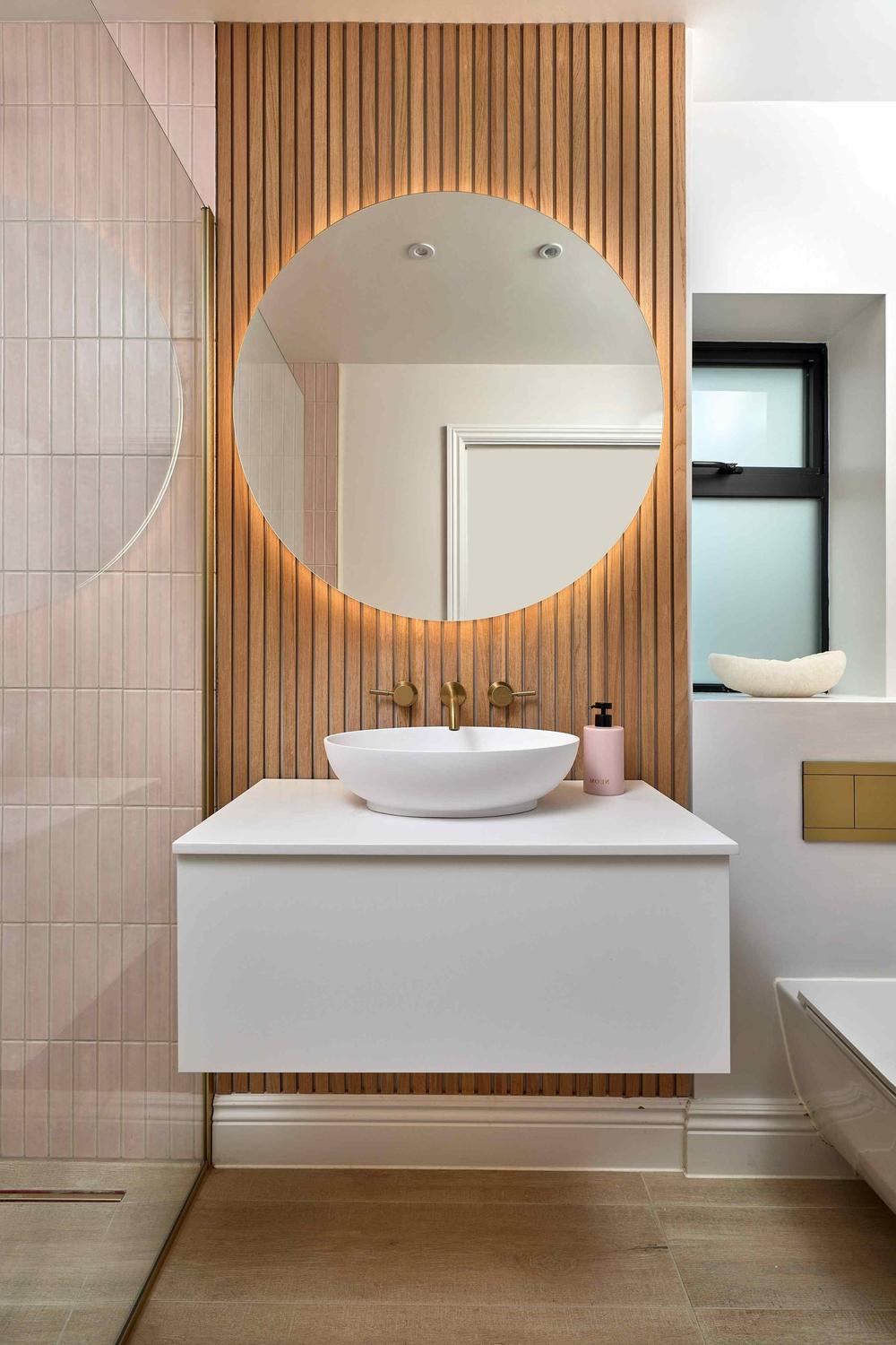 Baño moderno con mueble de baño blanco y paneles de madera