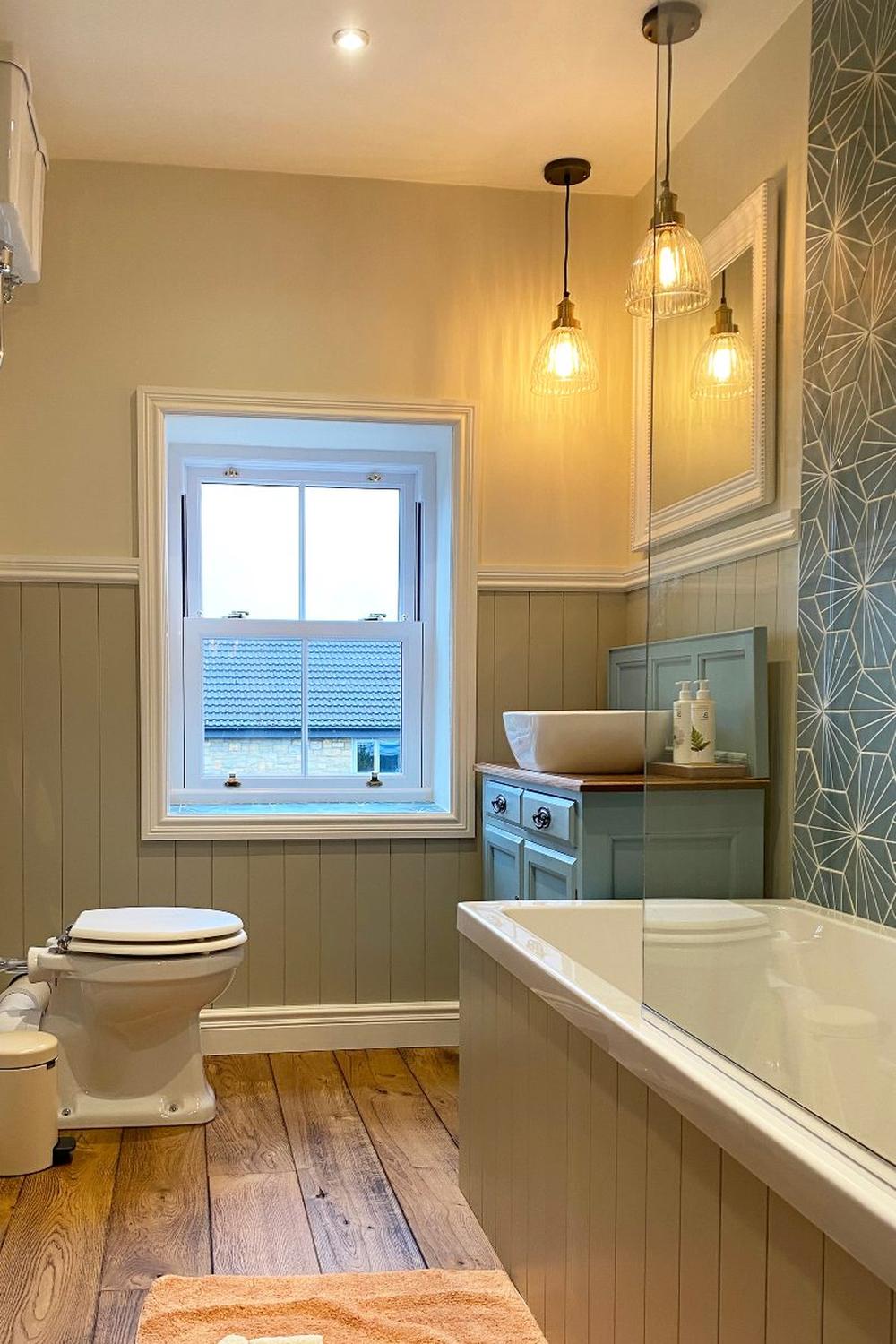 Baño que combina elementos modernos y rústicos con paneles de madera