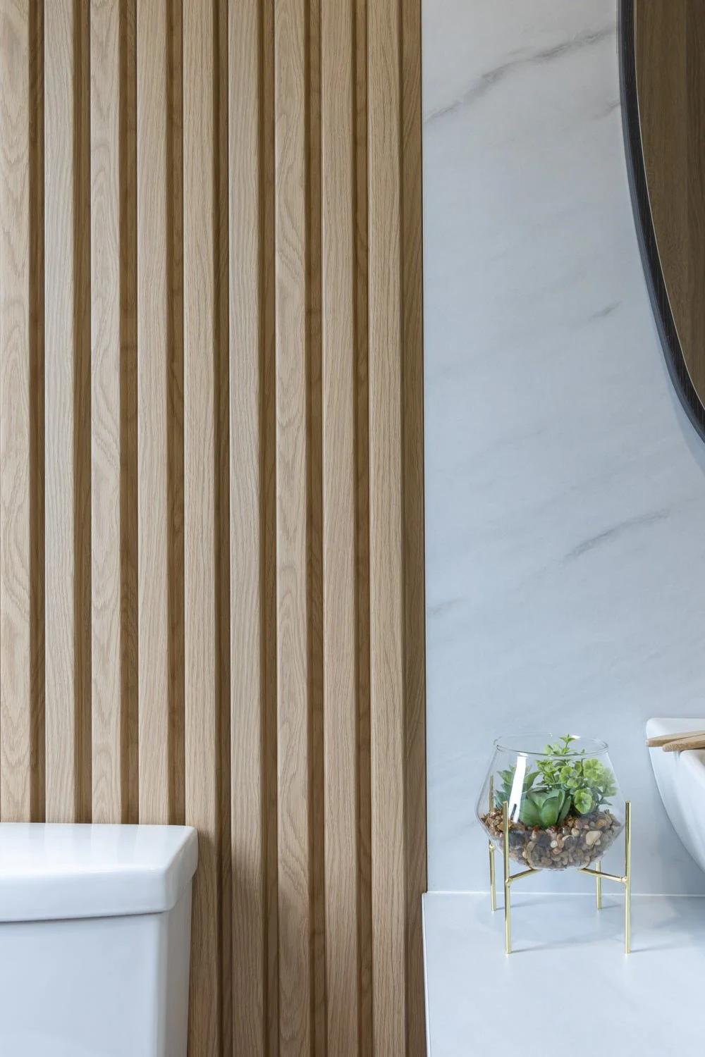 Baño elegante que combina paneles de madera y mármol