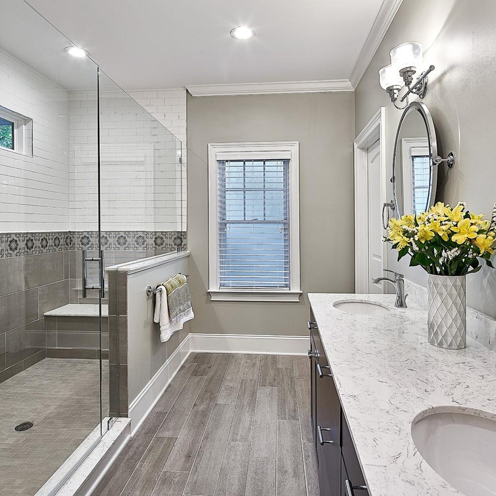 Contemporary bathroom featuring a wood tile floor, double sink vanity, and natural accents.