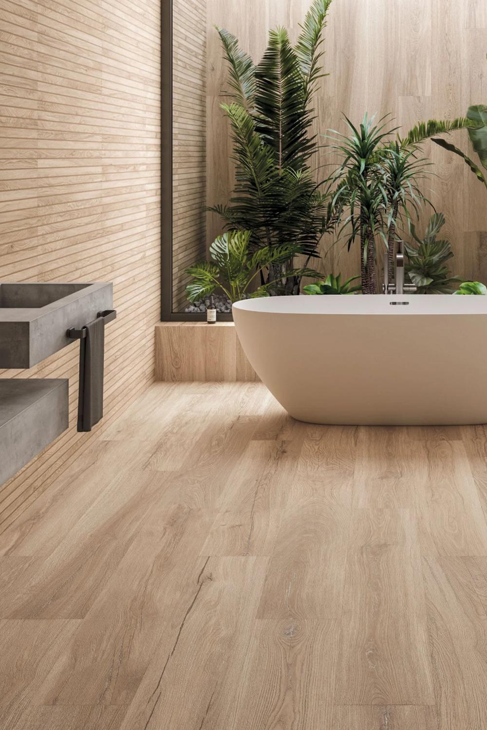 Modern bathroom with warm beige tiles, freestanding tub, and natural accents.