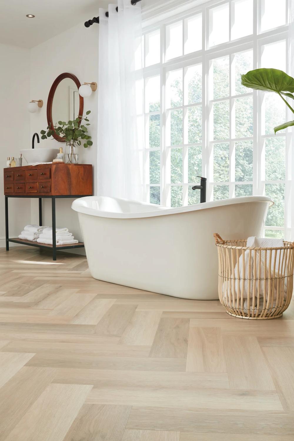 Beautiful bathroom with herringbone wood tile floor, chic vanity, and natural elements.