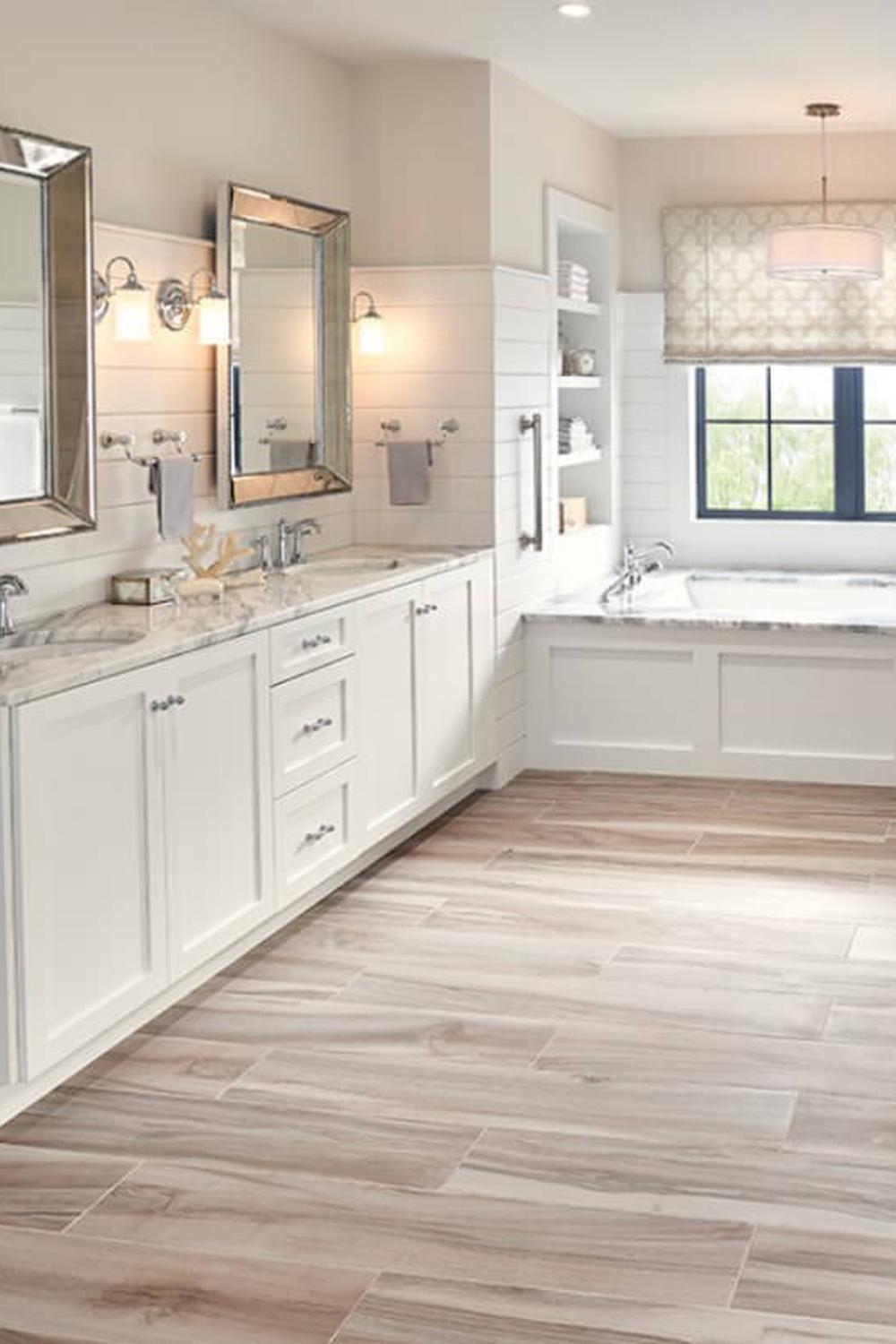 Elegant bathroom with a light wood tile floor, spacious vanity, and soothing decor.