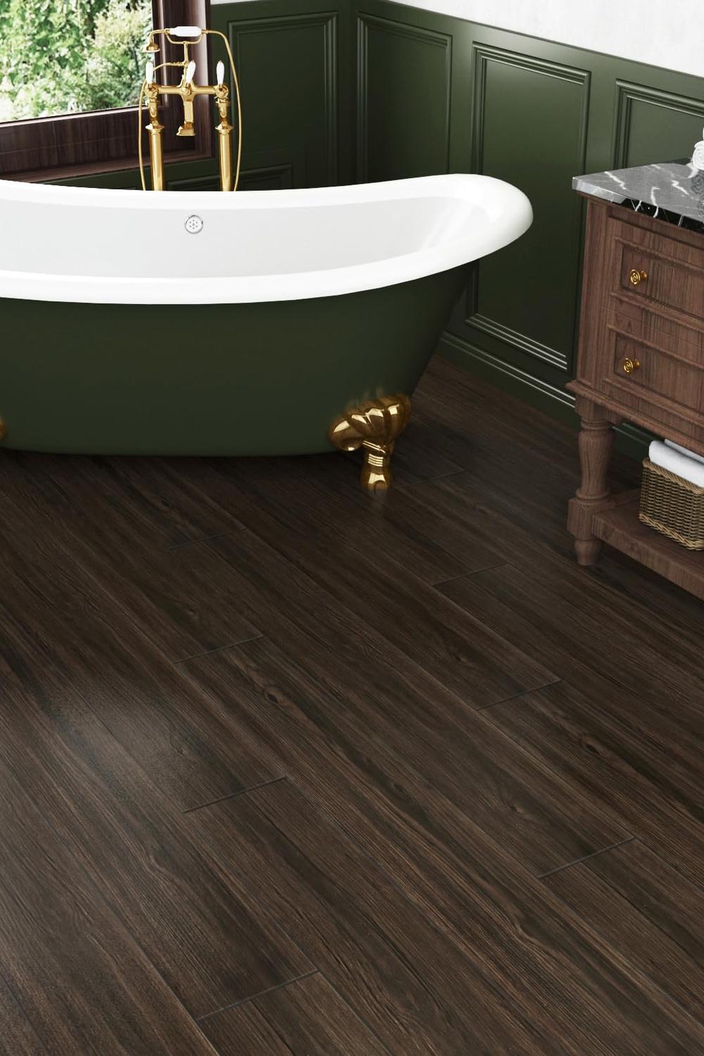 Stylish bathroom featuring a dark wood tile floor, vintage tub, and elegant accents.