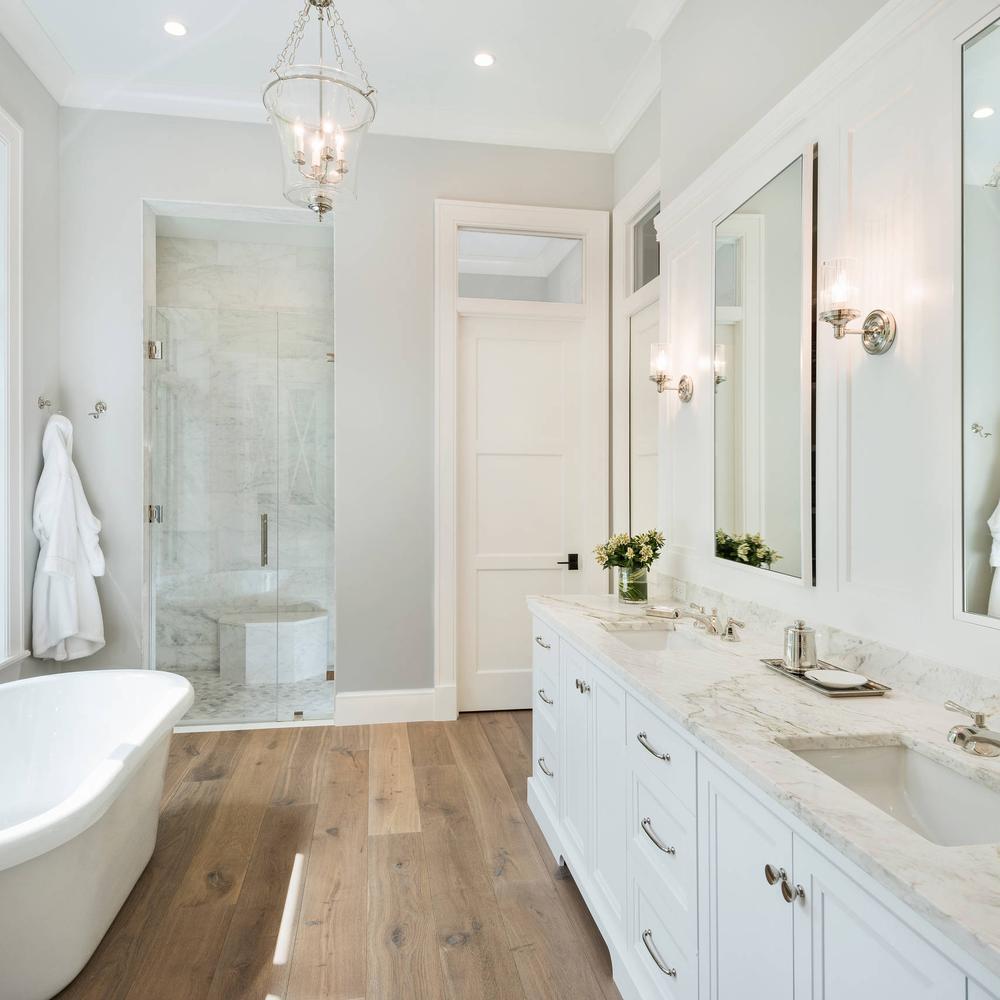 Chic bathroom with a light wood tile floor, elegant decor, and natural light.