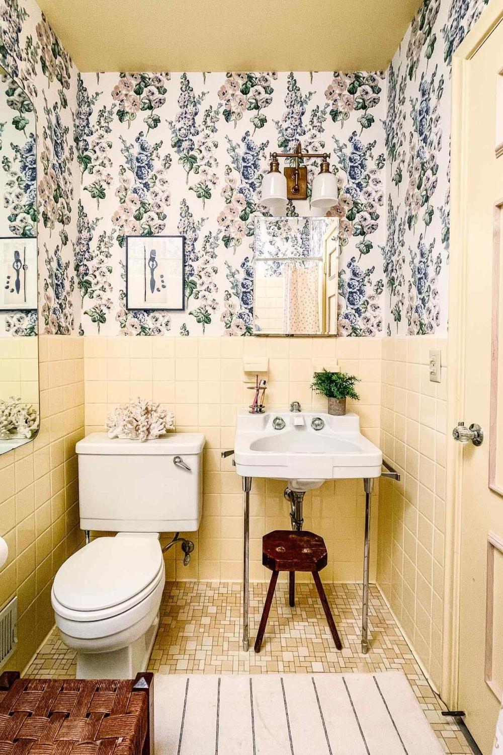 A playful yellow bathroom adorned with striped wallpaper and vintage decor for a charming aesthetic.