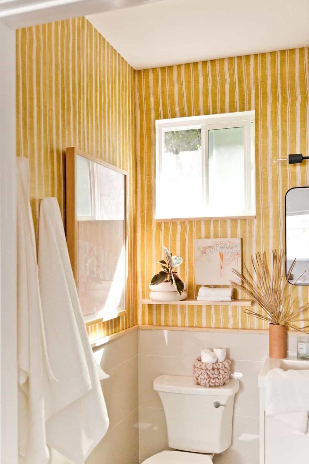 An elegant yellow bathroom with white accents, showcasing light and airy decor for a refreshing atmosphere.