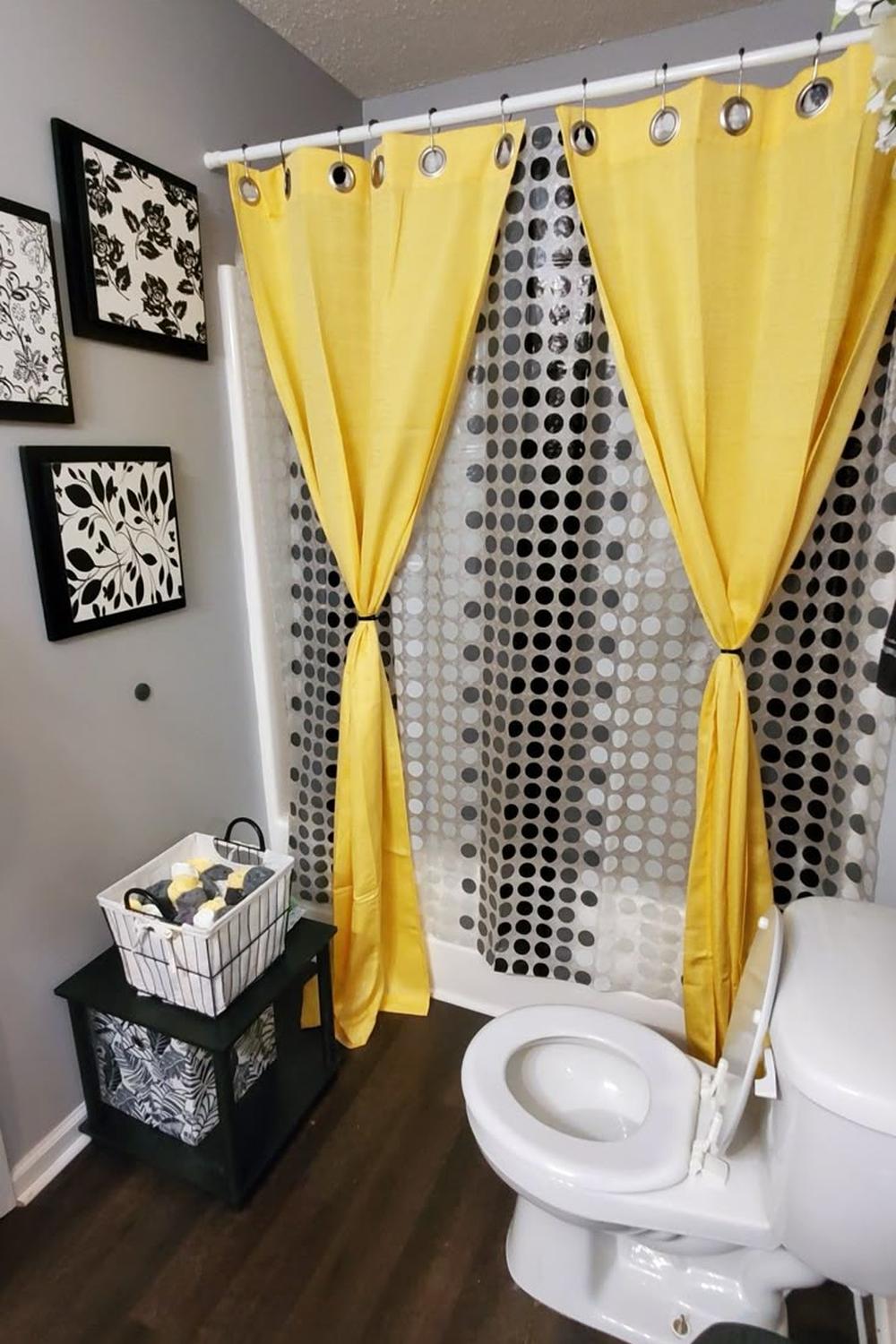 A stylish bathroom with a vibrant yellow shower curtain and contemporary decor.