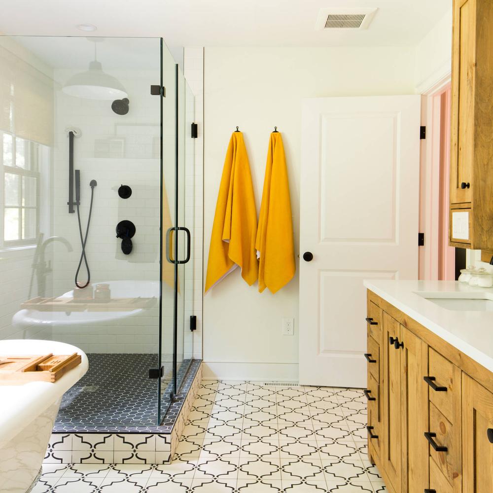 Baño boho con toallas amarillas y suelo elegante