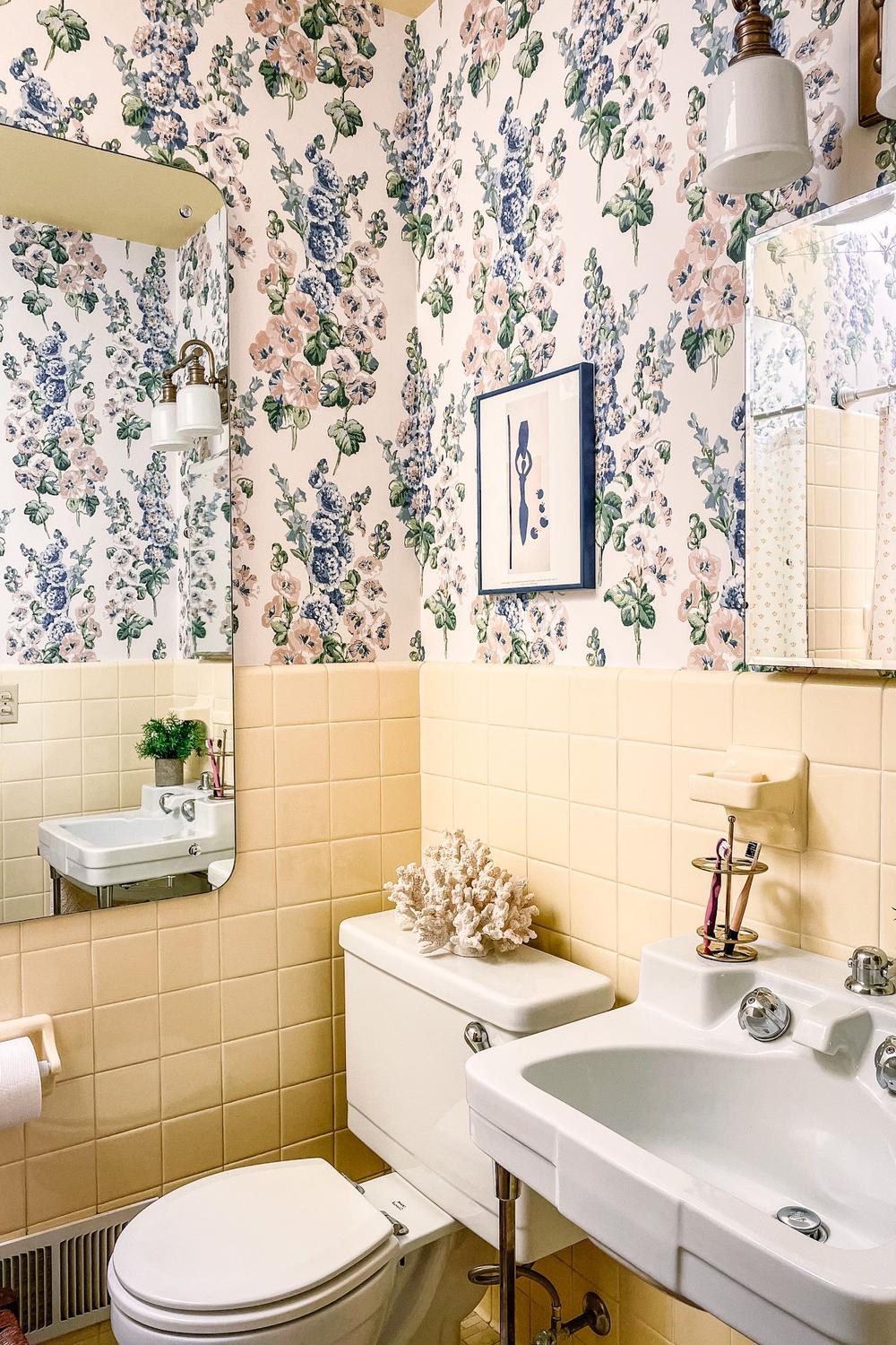 Charming small bathroom design with pale yellow tiles and floral wallpaper